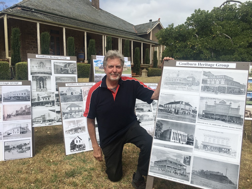 man with old photos of buildings and streetscapes