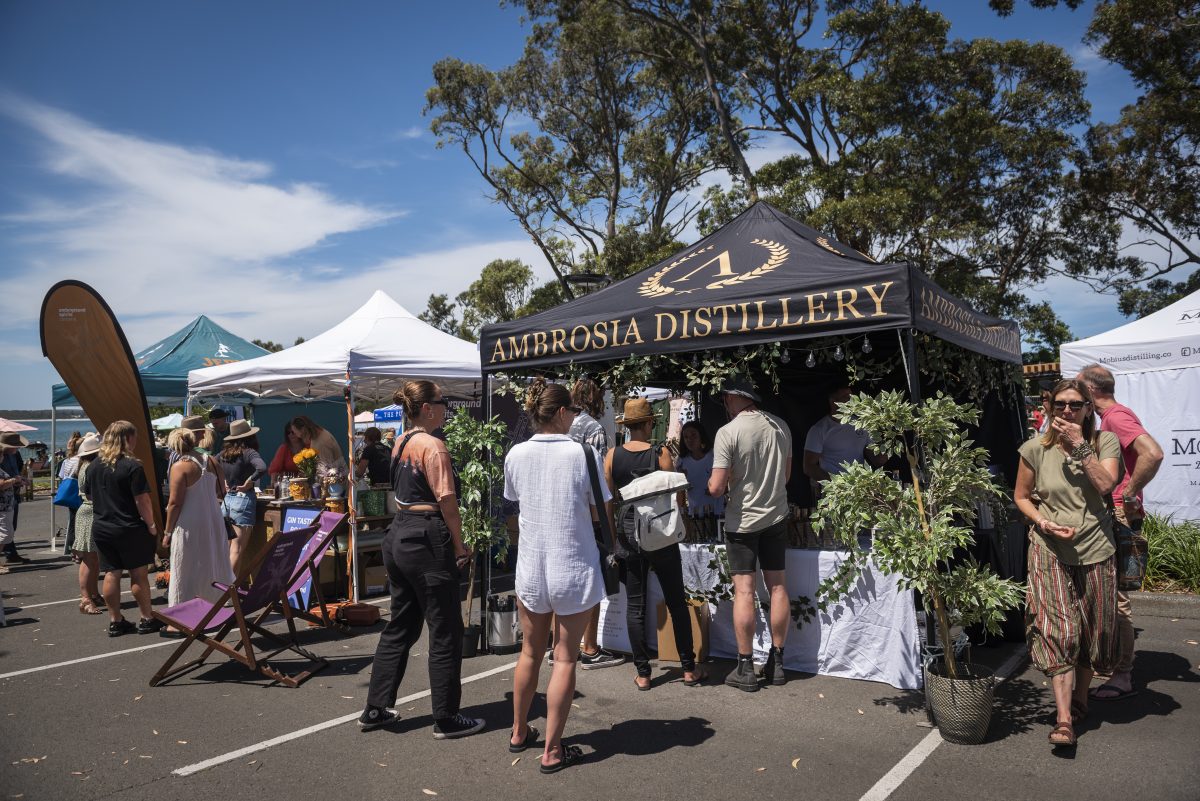 Ambrosia Distillery branded marquee with queue of customers.