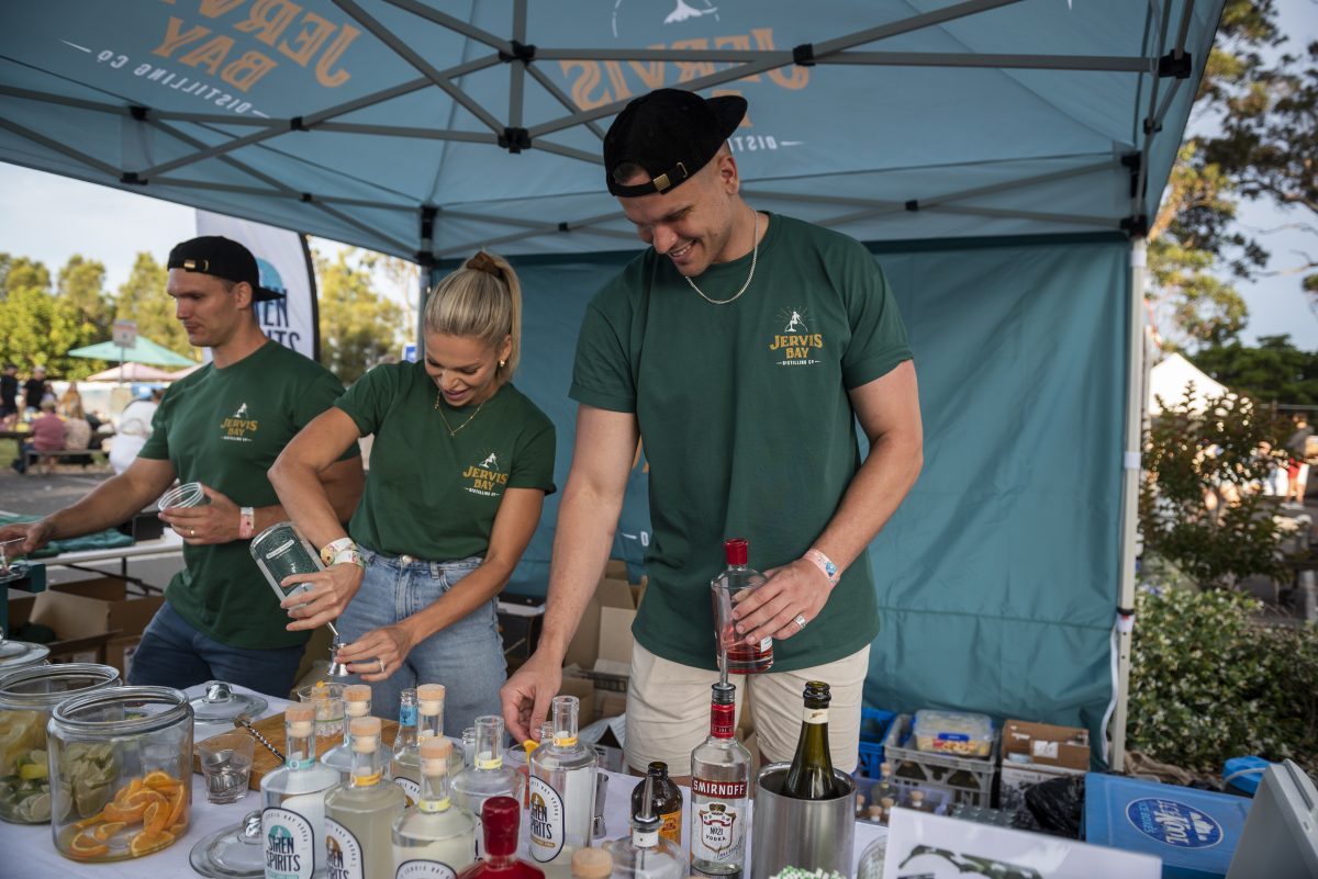Three people wearing Jervis Bay Distilling branded shirts pour drinks.