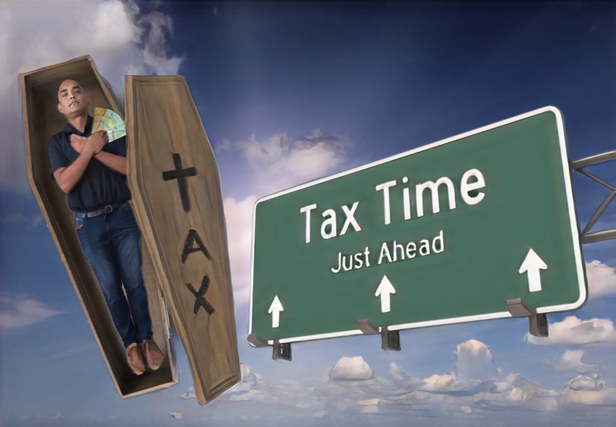 Oliver Jacques in a coffin with a tax time sign