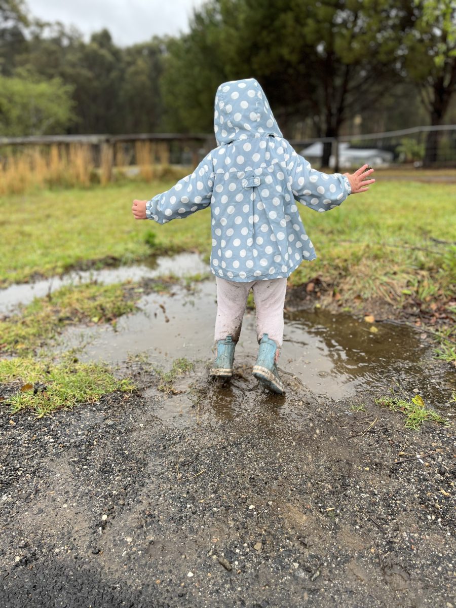 Child jumping in puddle