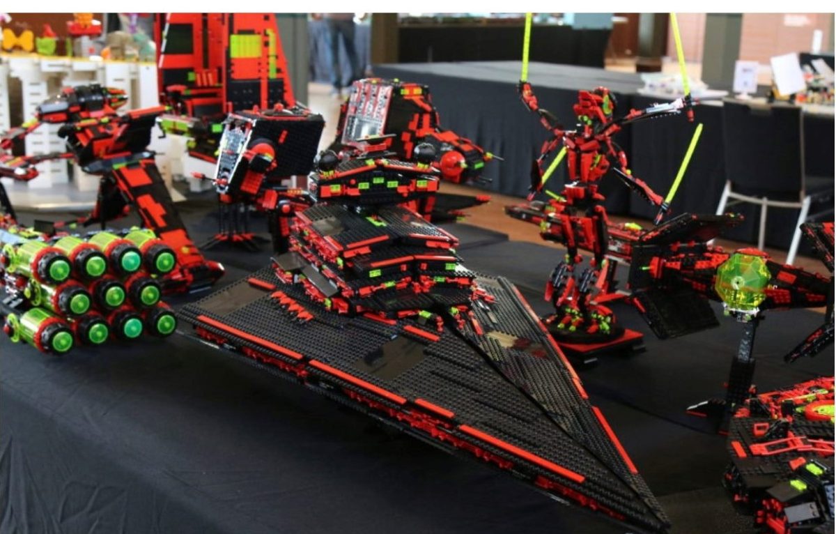 A few red, black and orange pieced LEGO sets on black table.