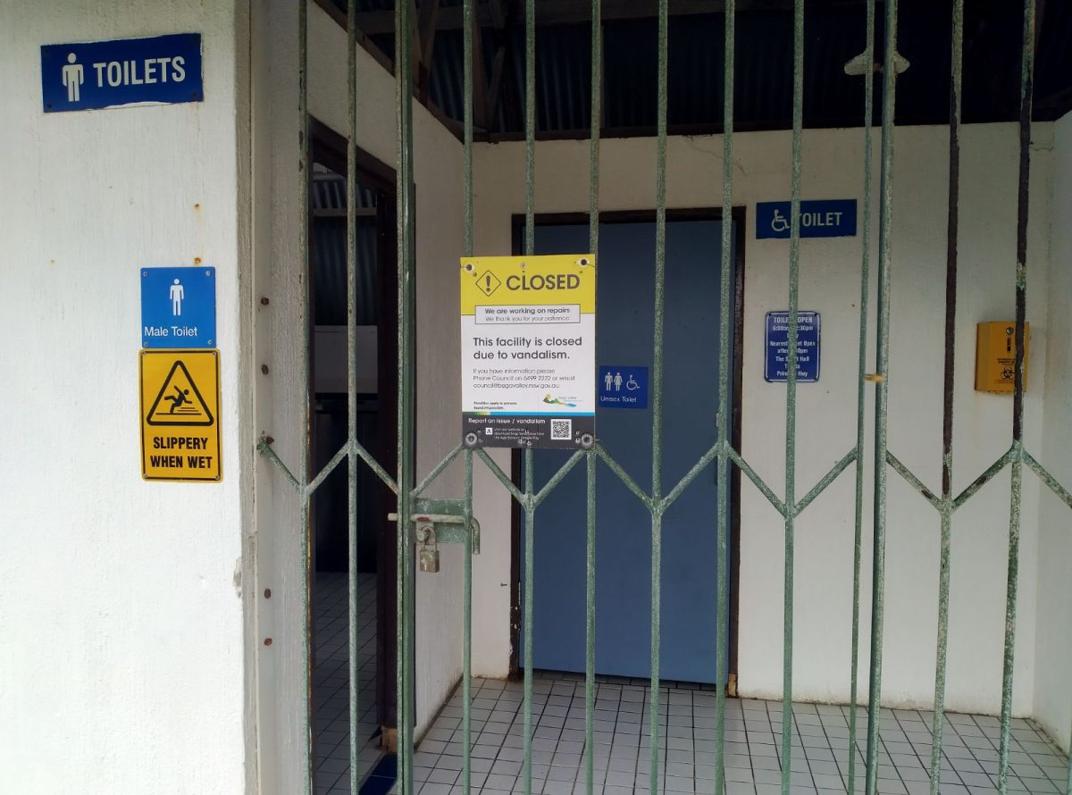 A toilet block locked with a sign