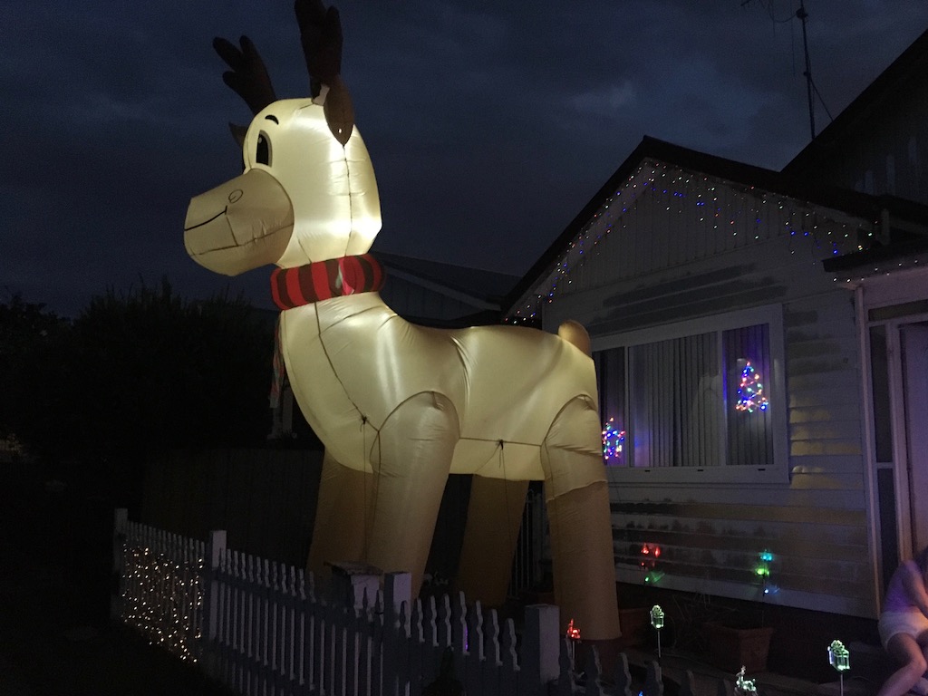 A blow-up reindeer in front of a house.
