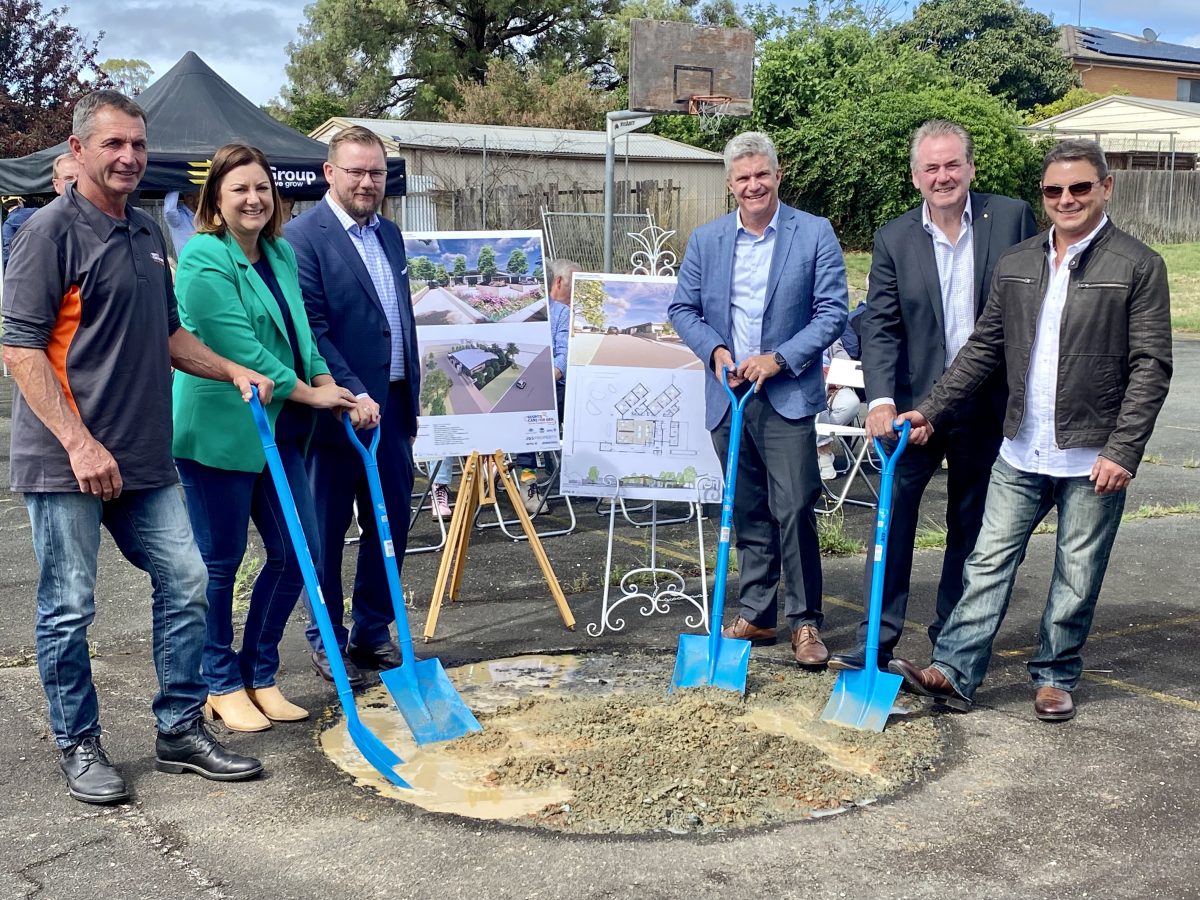 Six people standing together with shovels