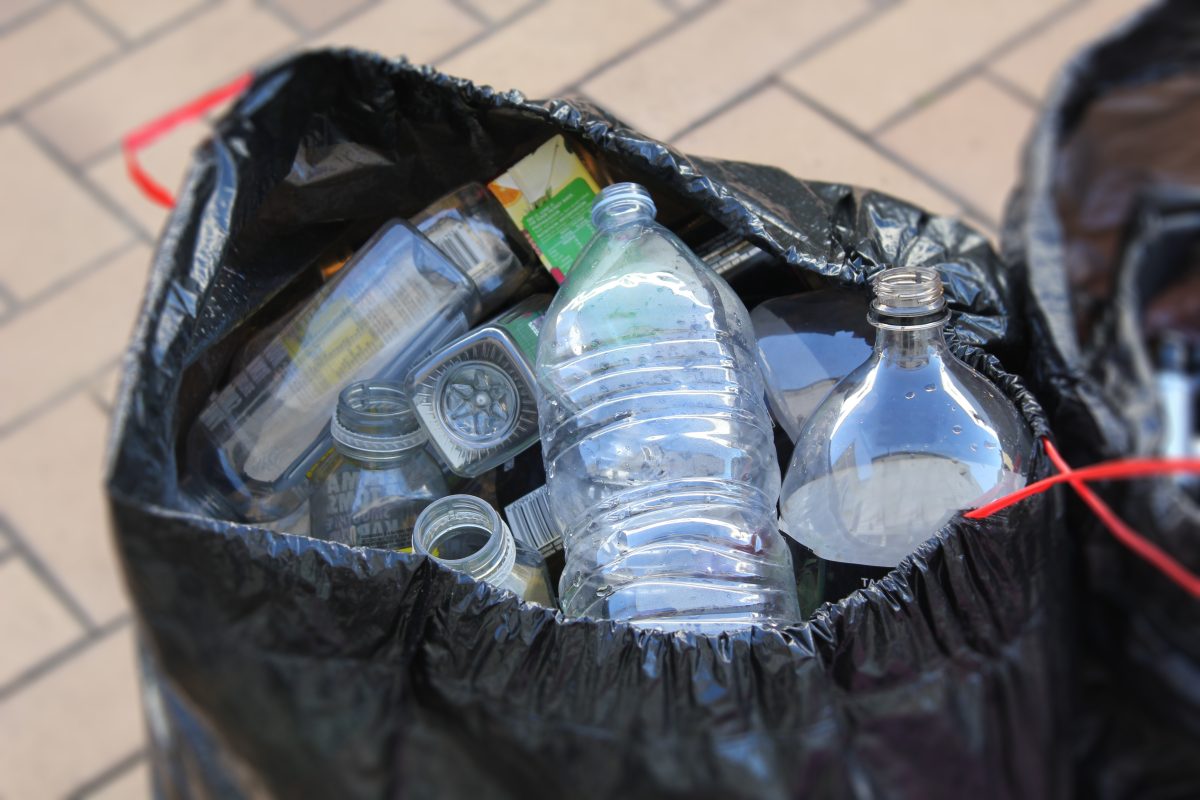 A black garbage bag of plastic bottles