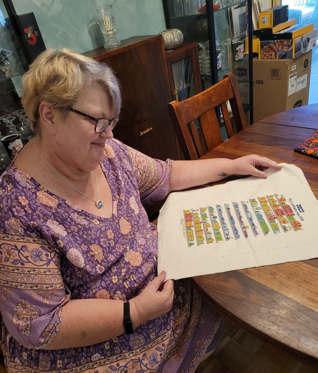 Woman looking at piece of cross-stitch