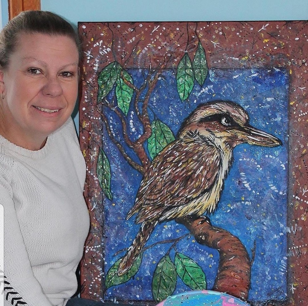 Woman in front of painting of a kookaburra
