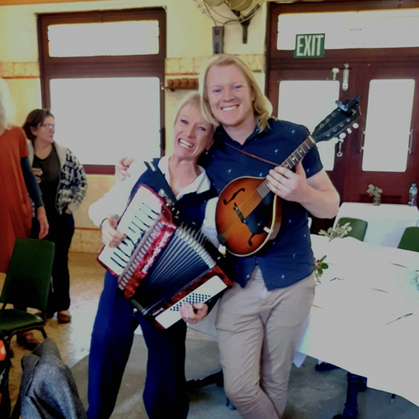 Woman and man playing accordian and mandolin.