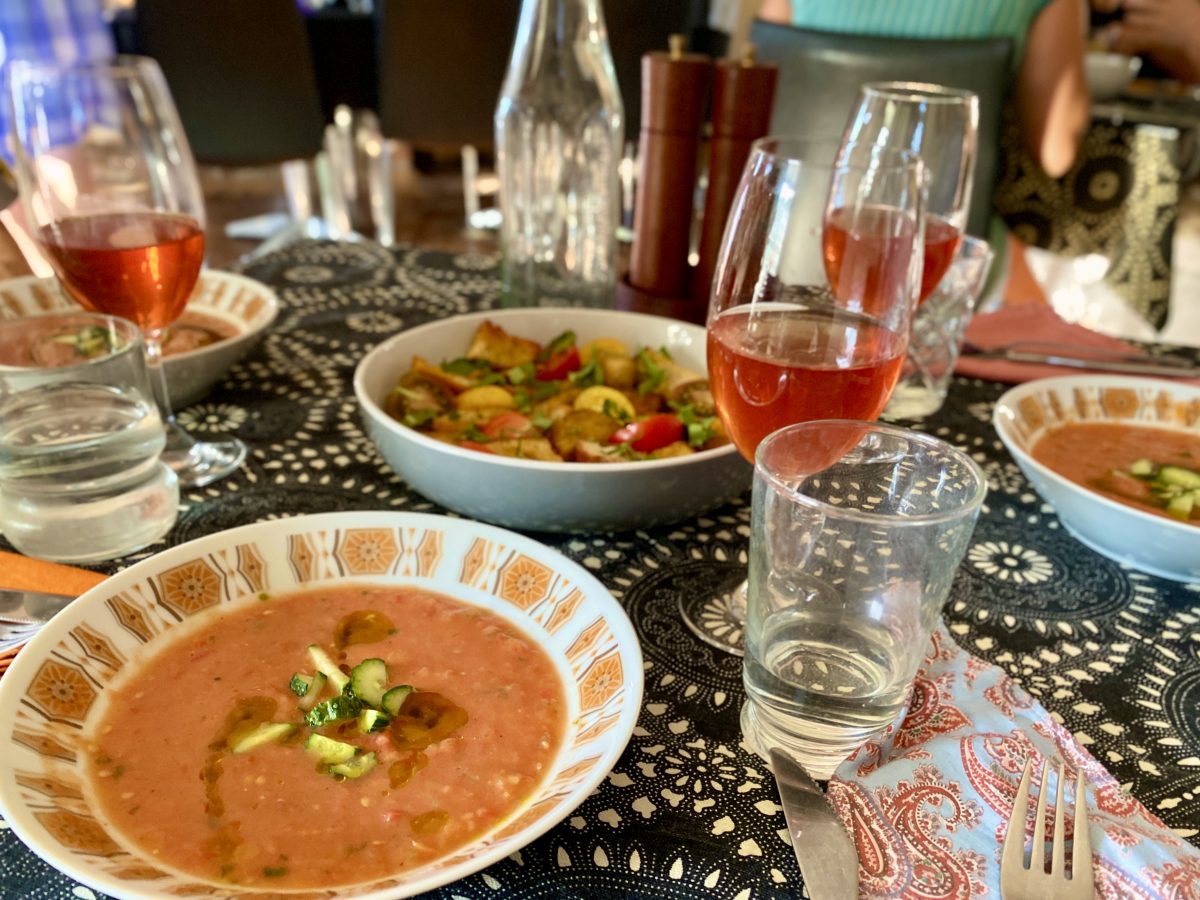 Gazpacho soup and panzanella salad on patterned tablecloth.