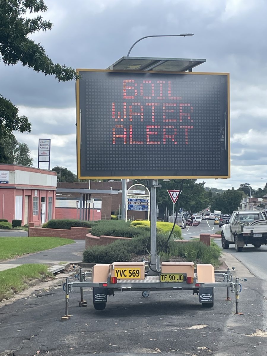 Boil water alert sign beside road