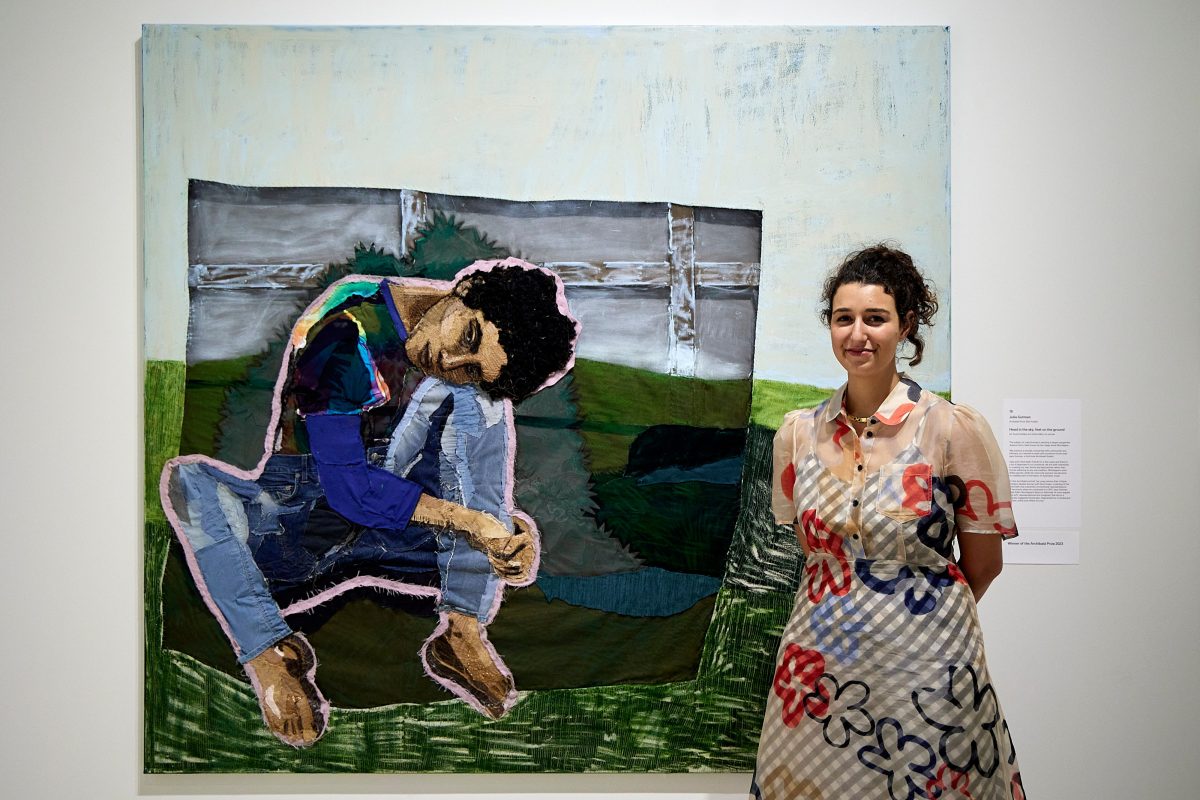Julia Gutman standing by her artwork