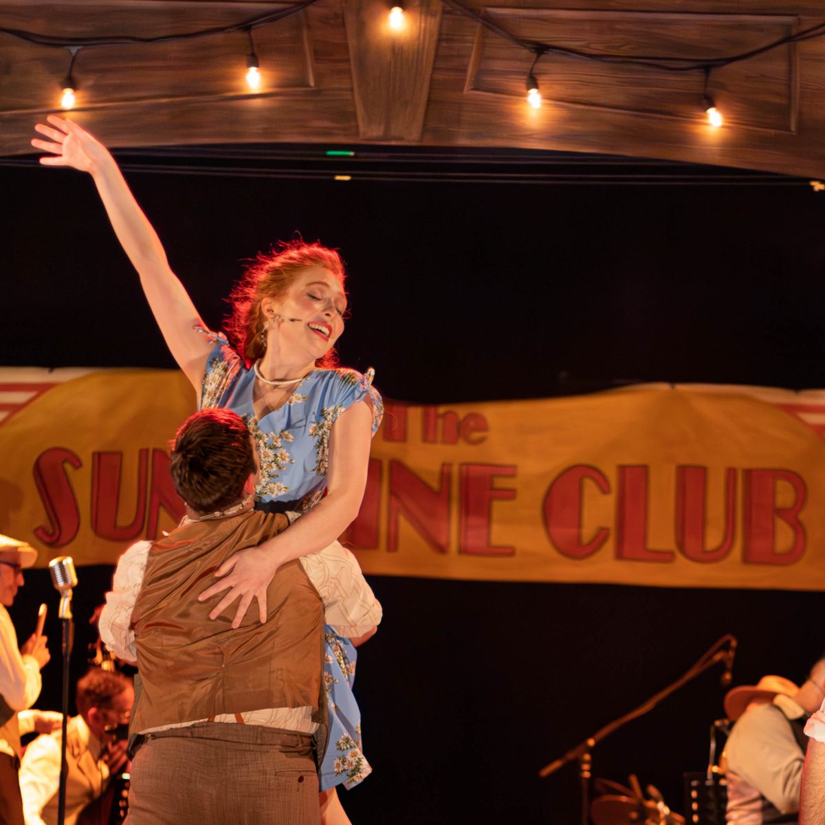 Two actors in costume, a man holding a woman off the ground