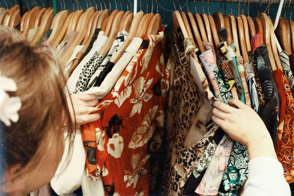 A woman looking through a rack of clothes