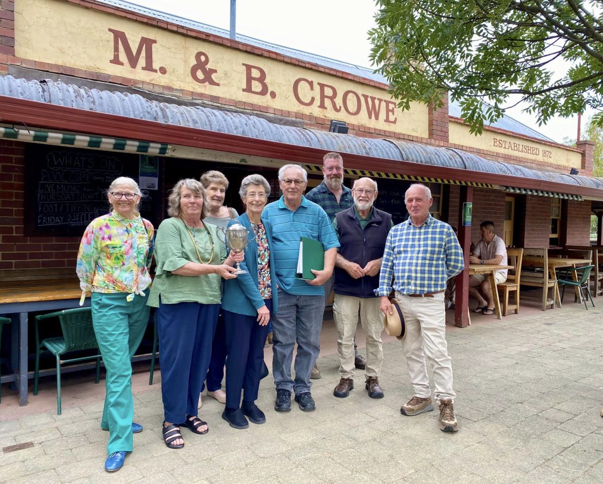 Eight people outside Crowe's Wine Bar holding silver cup 