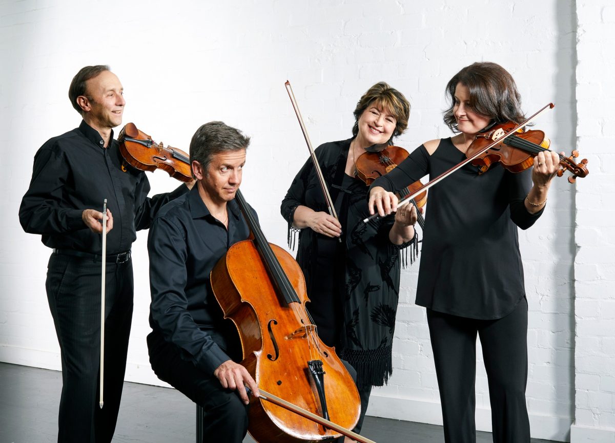 Four people dressed in black with their instruments