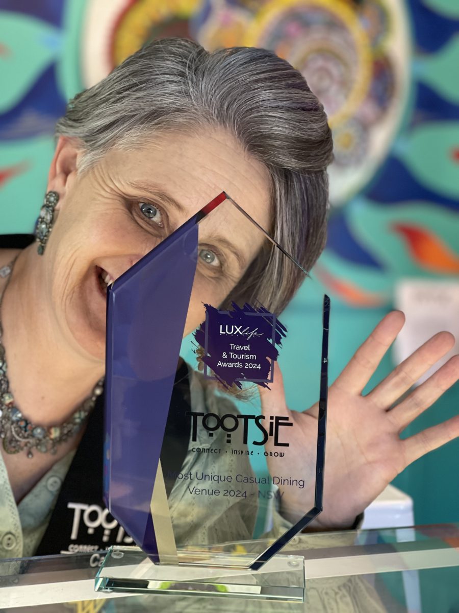 Woman waving behding glass trophy