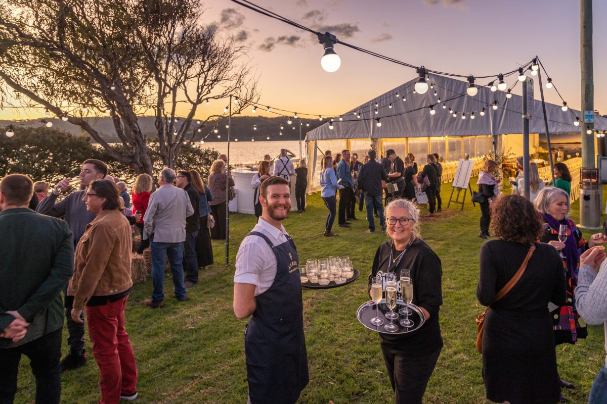 People serve oysters at the Narooma Oyster Festival by the Wagonga Inlet