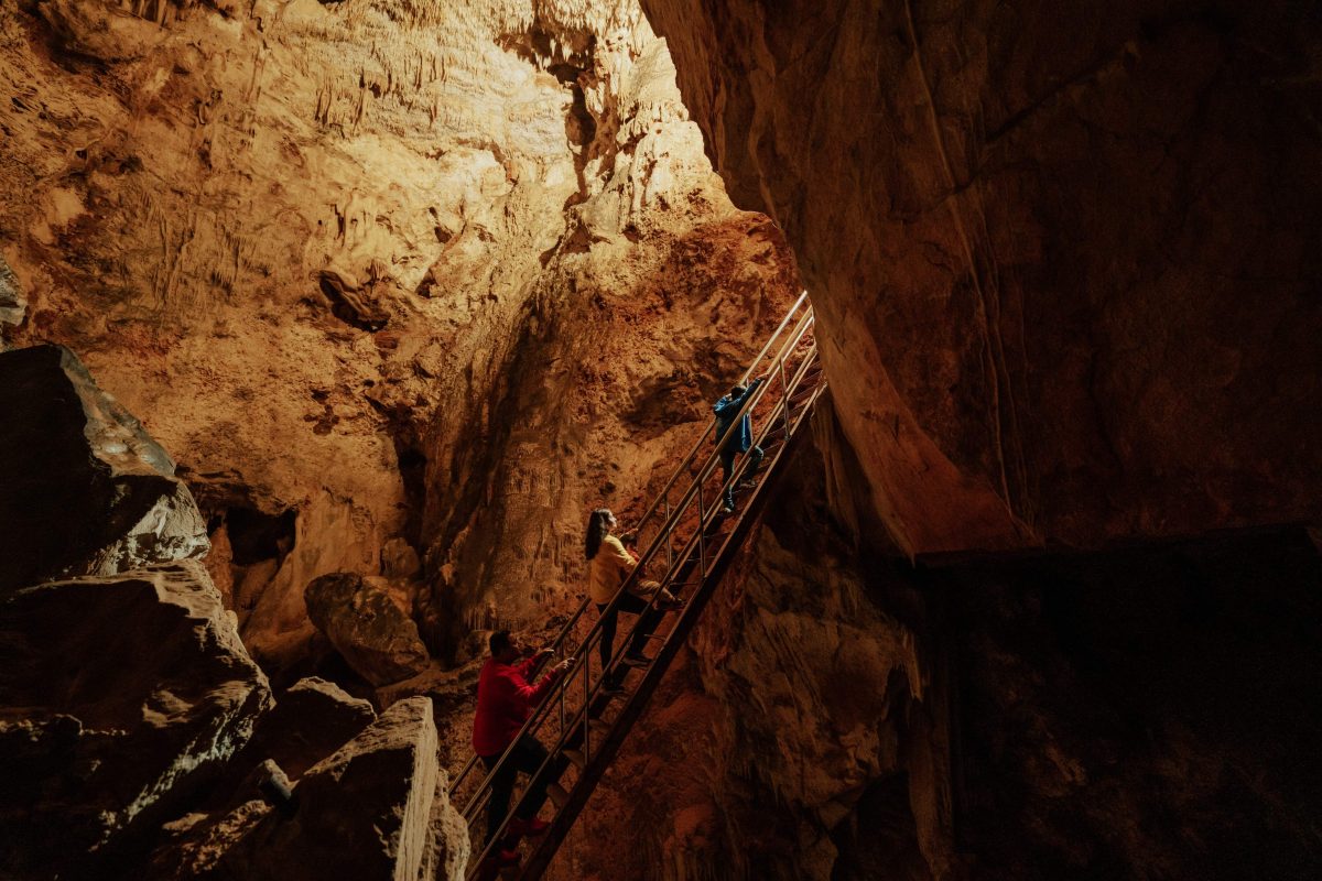 People walking up steps in cave