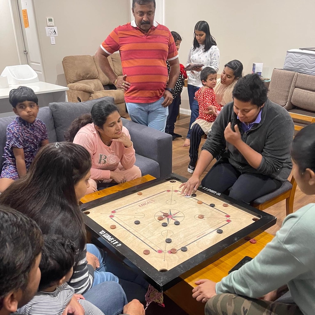 Friends playing carrom, a tabletop game of Indian origin, in Goulburn. Indian families gather regularly at the Veolia Centre for carrom, cards, chess and Zumba (led by Goulburn Multicultural Centre manager Heni Hardi). Cricket and indoor badminton are other popular sports.