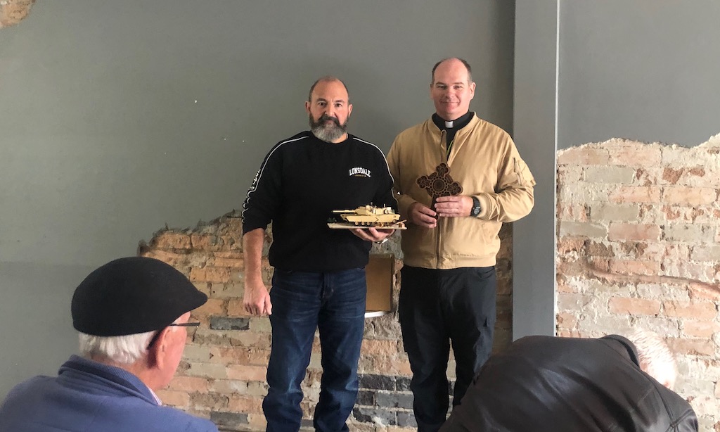 Goulburn parishioner Michael Lamarra presents military chaplain Father Damien Styles with a replica Abrams tank