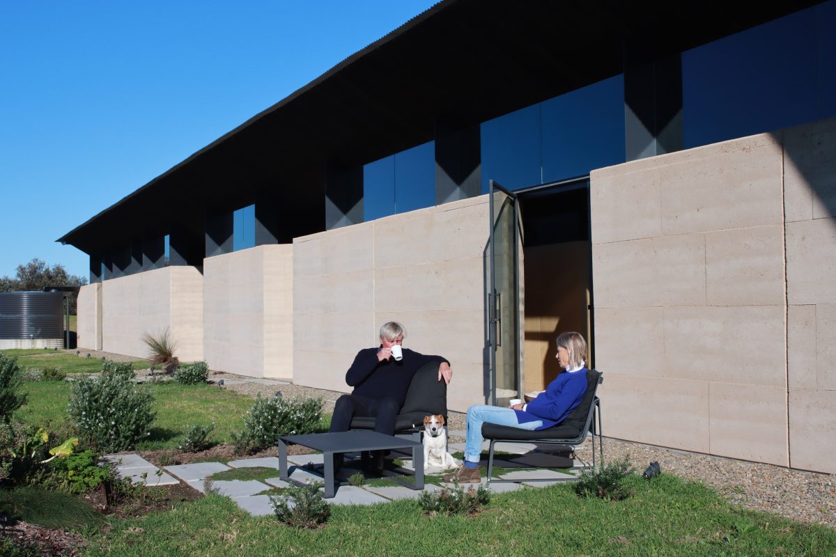 man and woman having coffee outside on their home patio