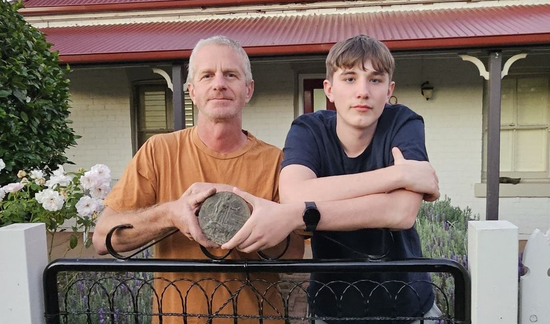 father, son and an old war medallion found in their backyard