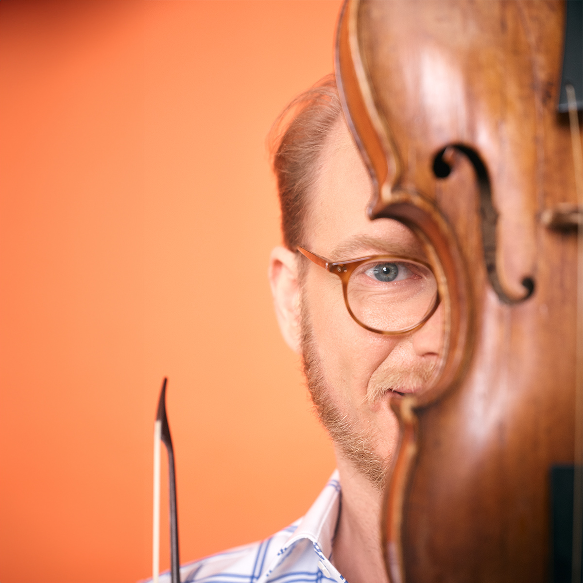 A man standing behind a violin