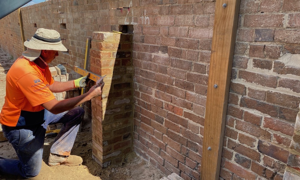 Checking levels as he goes, Matthew Chamberlain continues repairs on a brick wall in the Old Cathedral precinct.