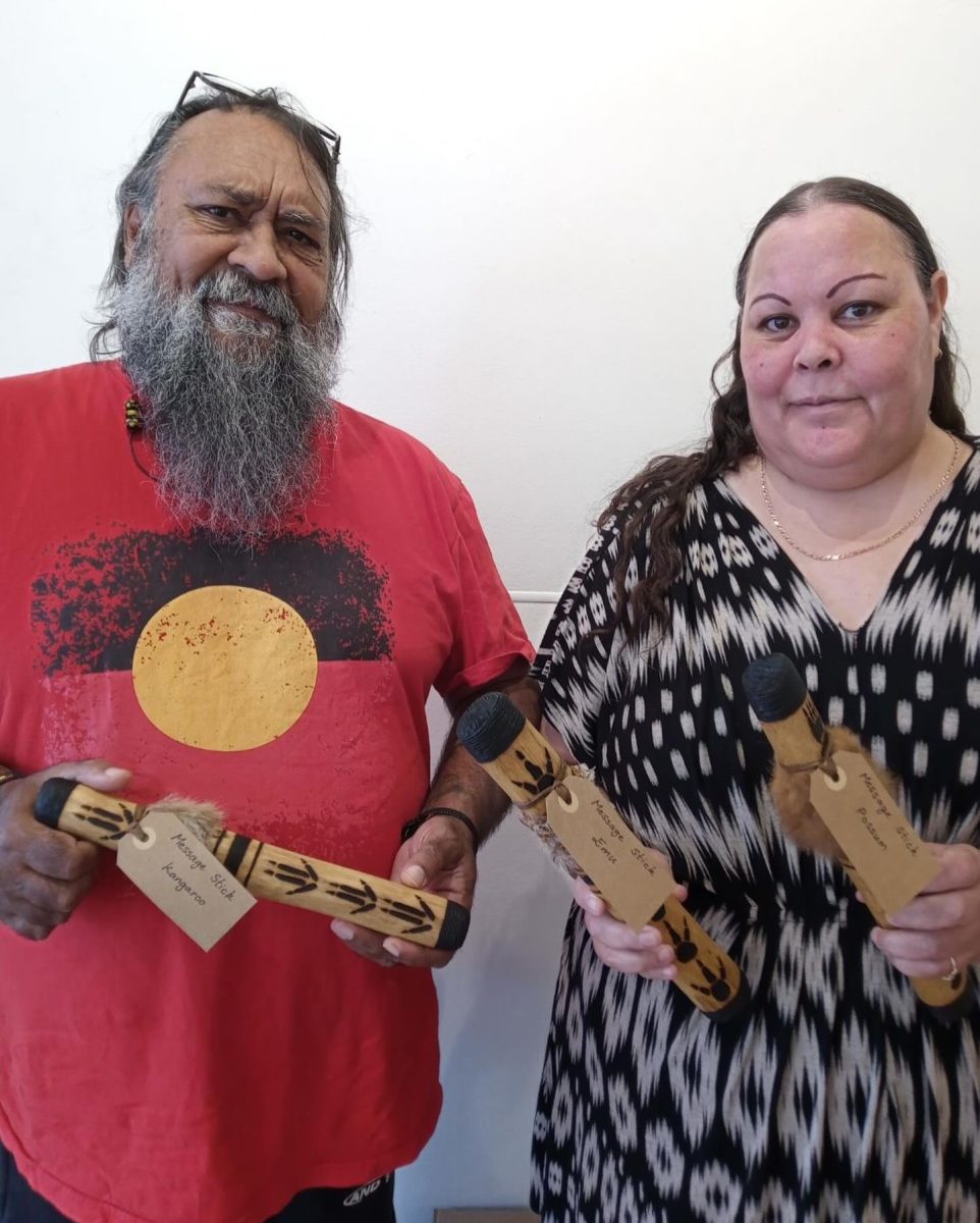 Two people holding message sticks