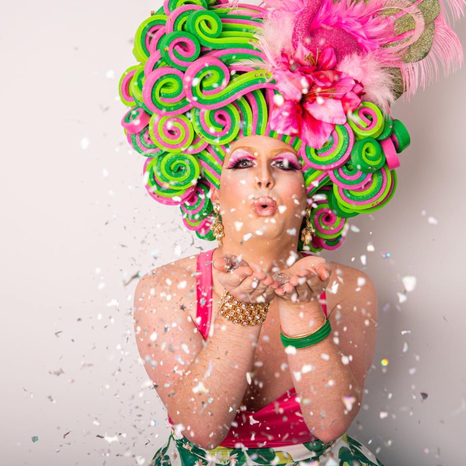 Drag queen wearing pink and green feathers 