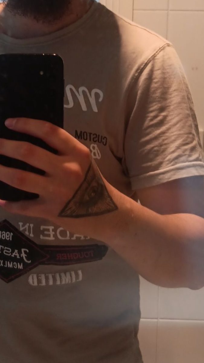 A triangle tattoo on the back of a man's hand