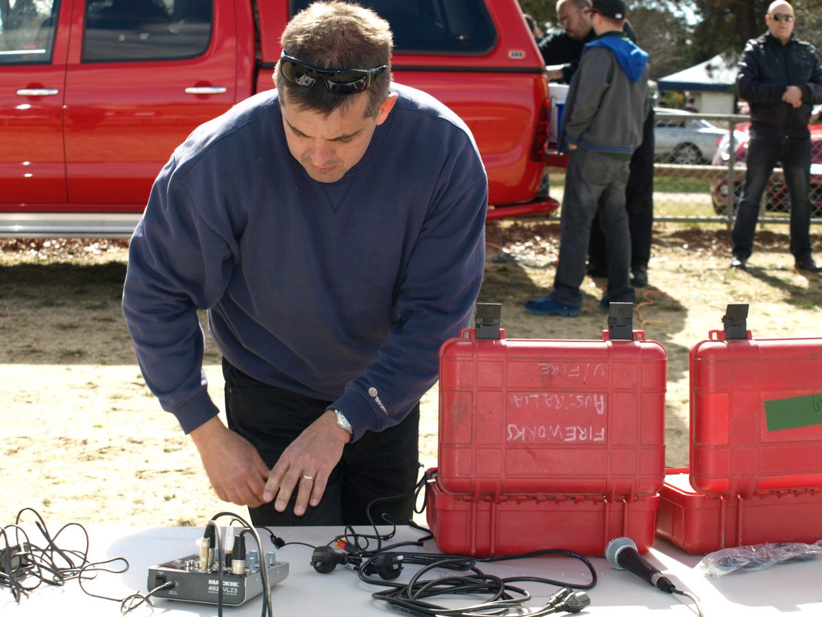 A man setting up equipment for a fireworks show