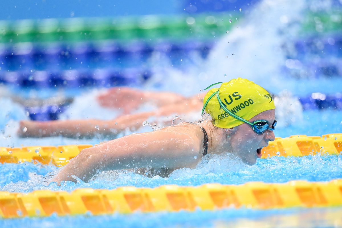 A woman swimming in a yellow cap