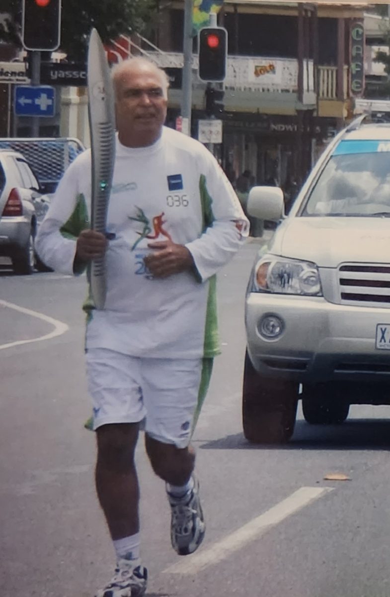 Man running with Commonwealth Games baton