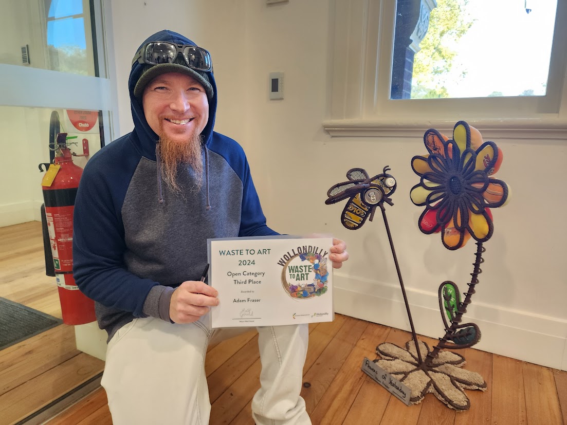 Man in hoodie holding certificate