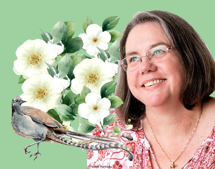 A smiling woman next to flowers