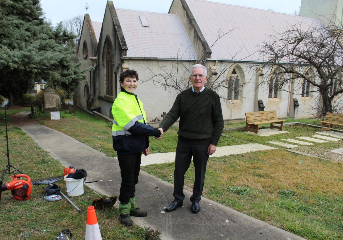 Boy in fluro shakes hands with man outside church 