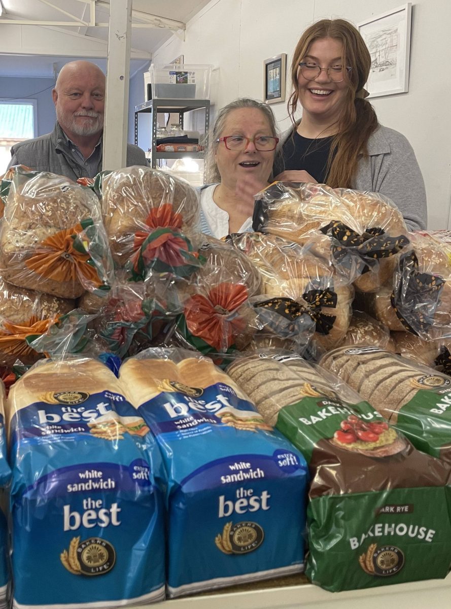 three people in front of stack of bread