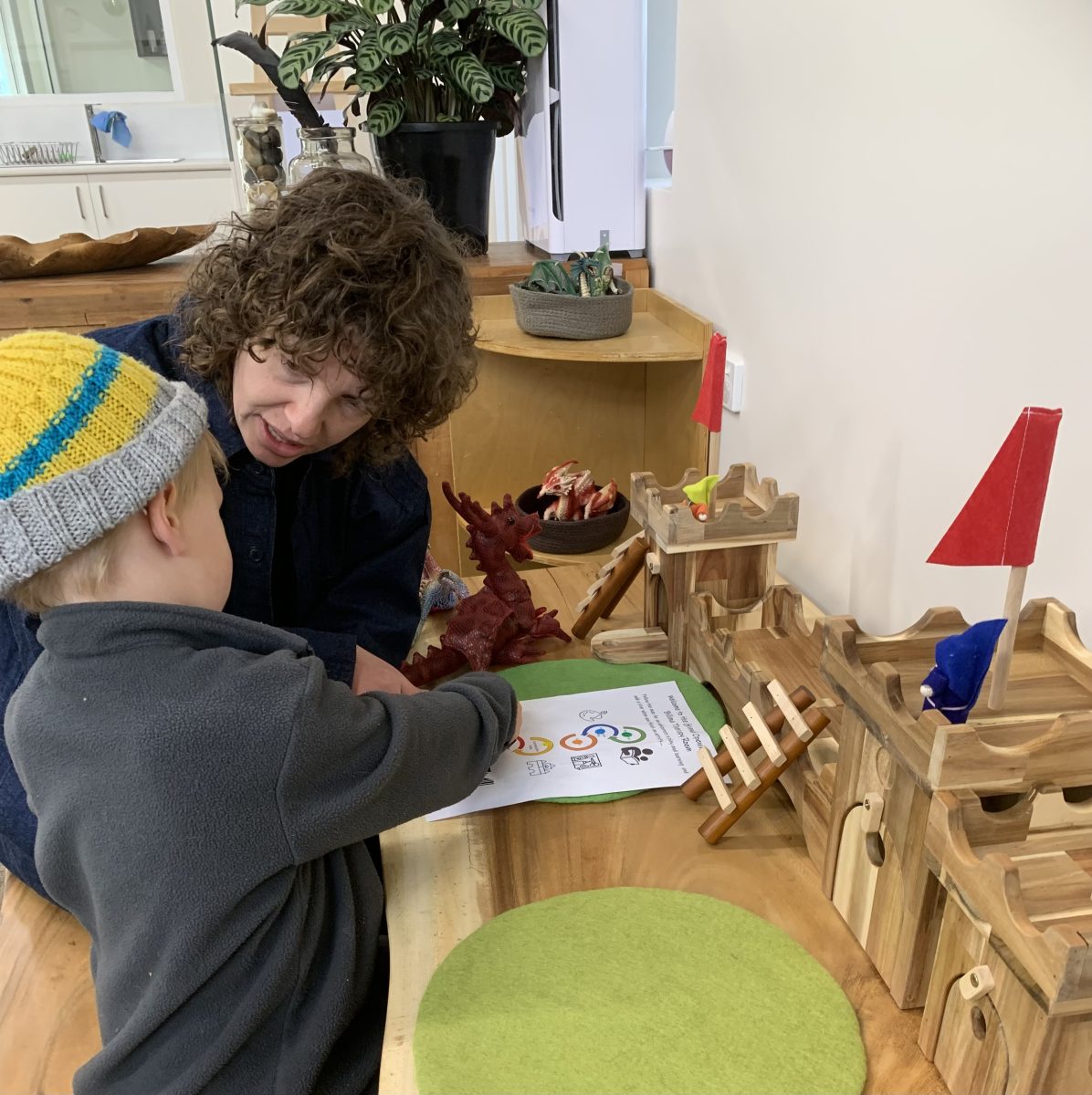 An adult helping a kid with a worksheet