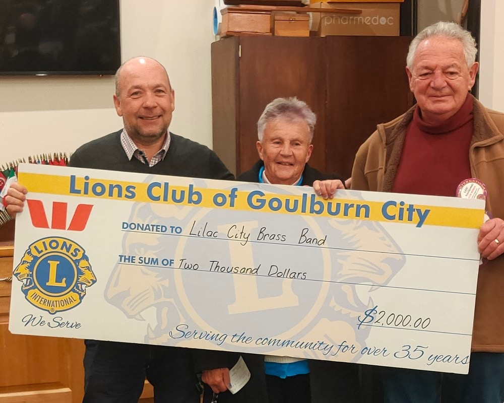 Band founder Andy Yule, Lions Club of Goulburn City president Prue Rickard and Lions Club member Lou Smetkowski, with a replica $2000 cheque the club has donated to help pay for the band’s insurance.