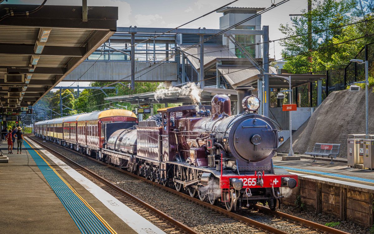 A steam train pulling out of a train station