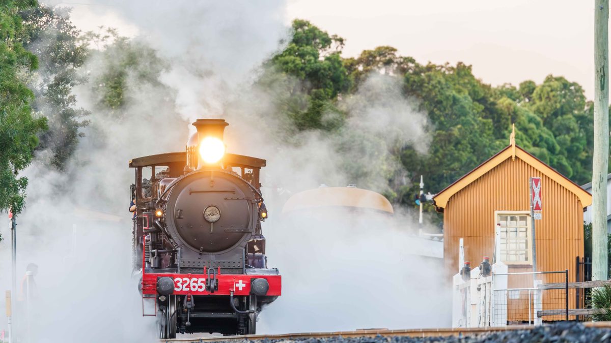 A steam train driving through smoke