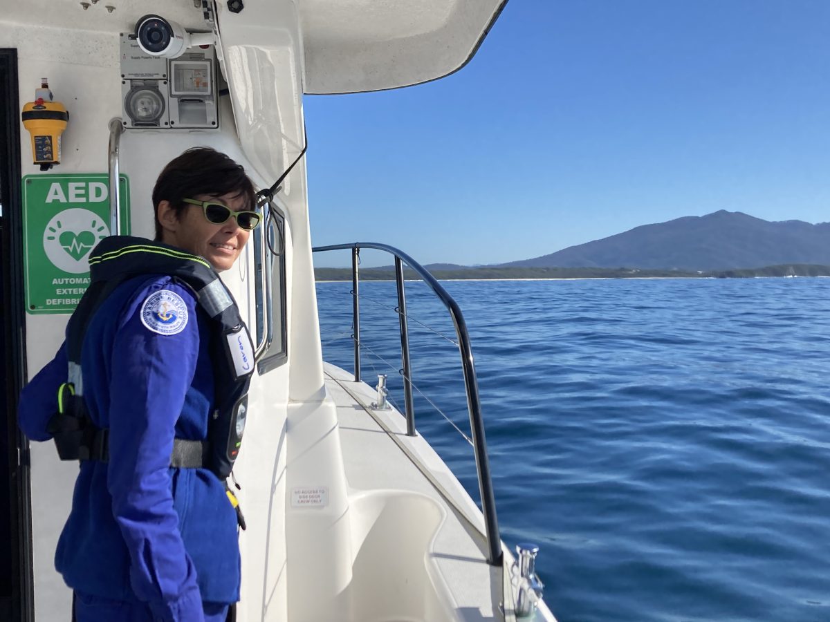 Marine Rescue NSW officer on boat and looking out over water