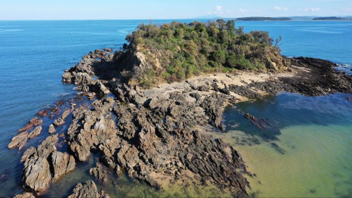 An aerial photo of an island with trees on it