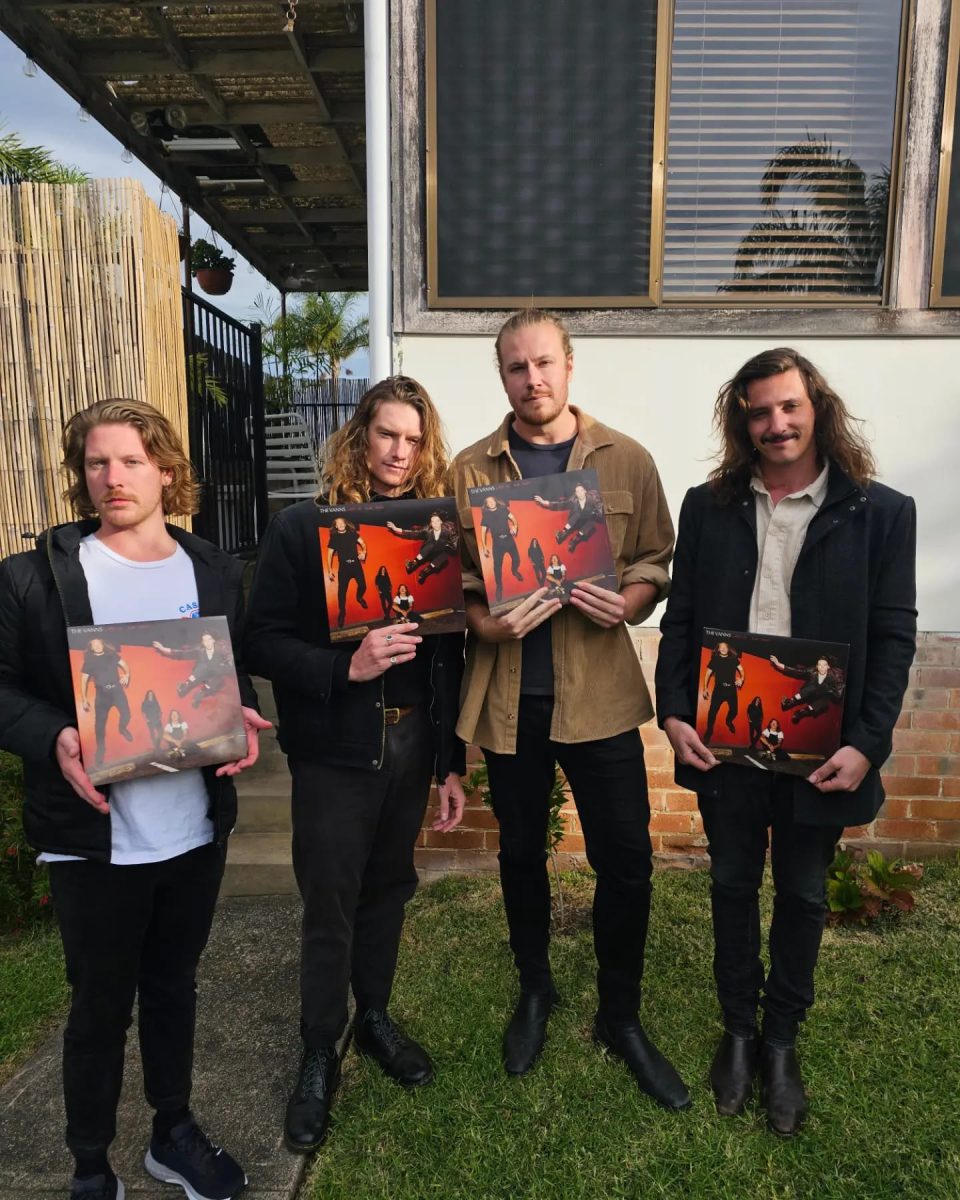 Four men holding a music album