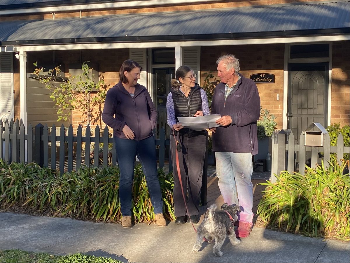 Auburn Street, Goulburn residents Meg Perriman, Gillian Webber and Geoff Henderson looking over plans for a new wombat crossing and cycleway outside the front of their homes. 