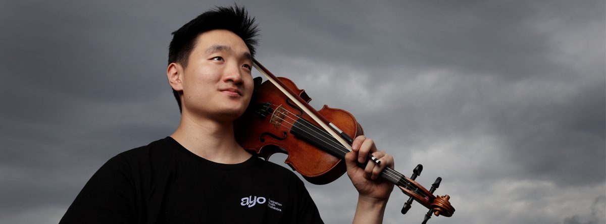 A young man with a violin on his shoulder