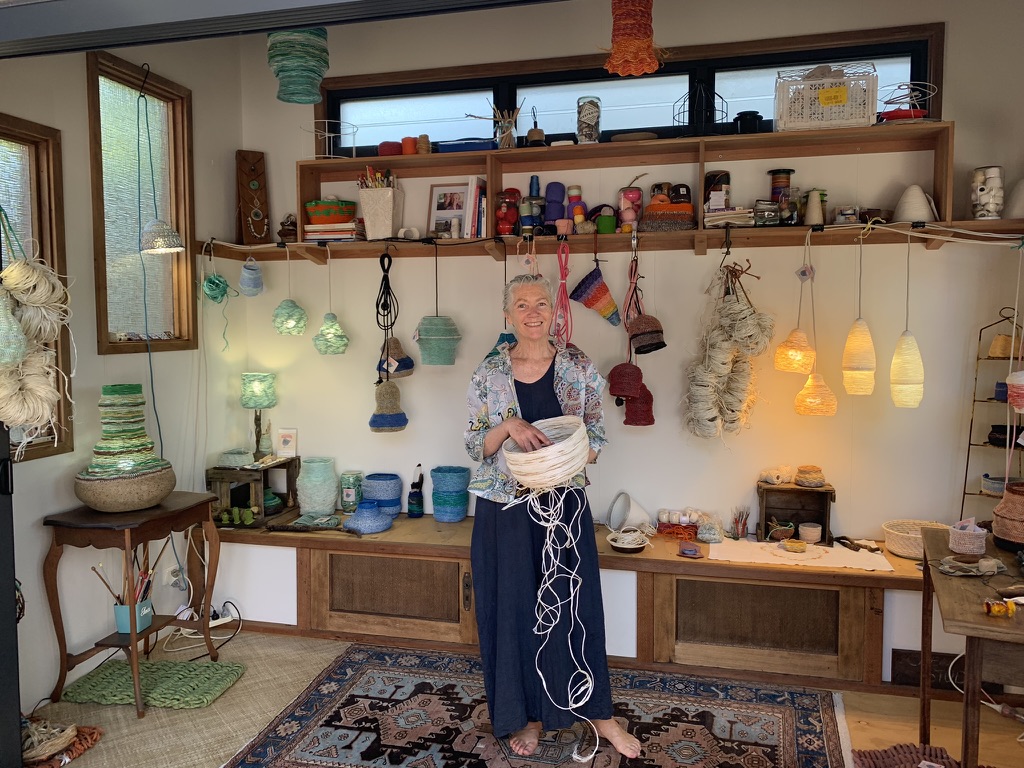 A woman holding a bowl in her art studio