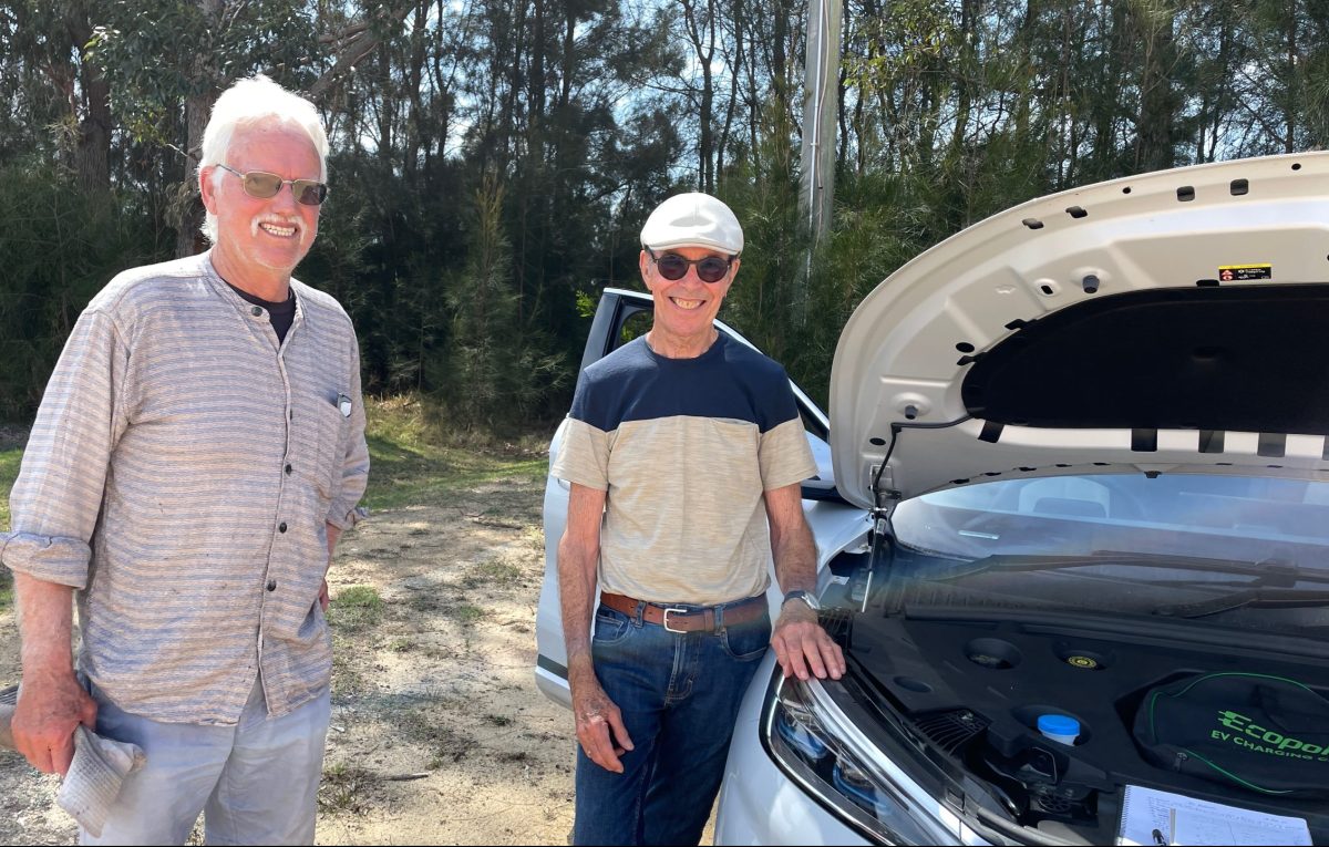 Stuart Absalom (right) showing his electric vehicle to a member of the public at a Renewable Cobargo EV Expo in Bermagui in October 2023. 